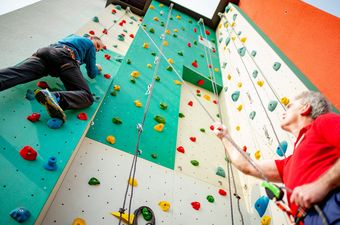 Therapeut sichert kletternden Mann