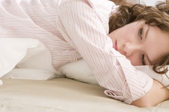 Frau liegt sorgenvoll im Bett