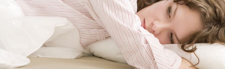 Frau liegt sorgenvoll im Bett