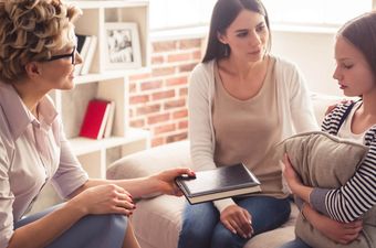 Psychologin spricht mit Kind und Mutter