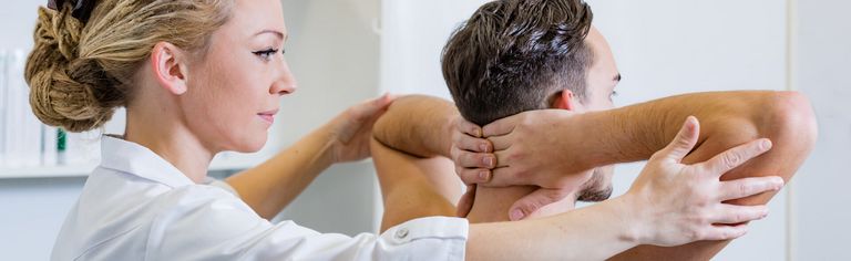 Pflegerin prüft Mann auf Beweglichkeit