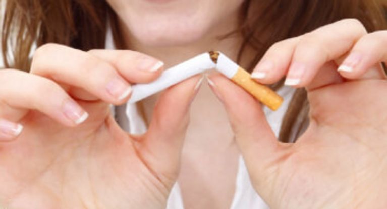 Junge Frau zerbricht einen Zigarette