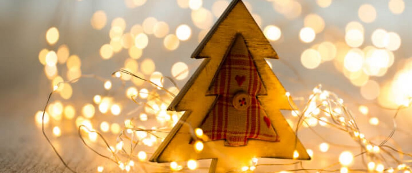 Weihnachtsbaum aus Holz mit Lichterkette auf einem Holztisch