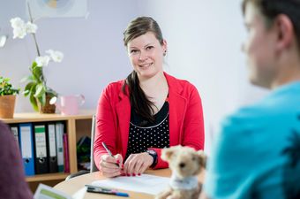 Therapeutin spricht mit Kind und Mutter